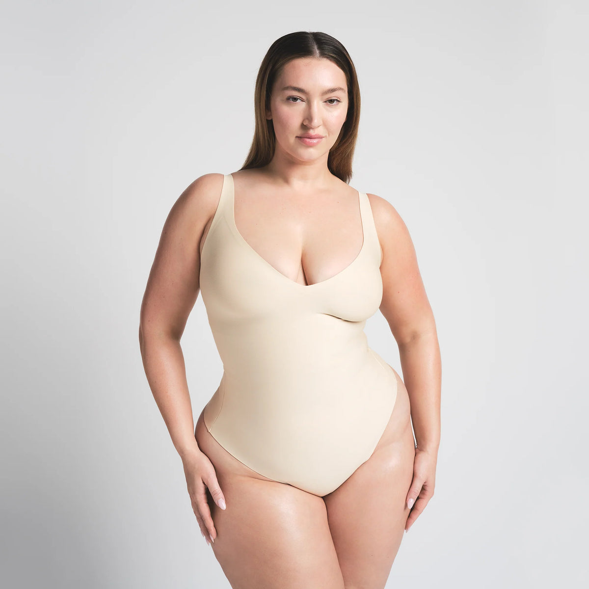 SKIMS BODY UNLINED PLUNGE THONG BODYSUIT | SAND